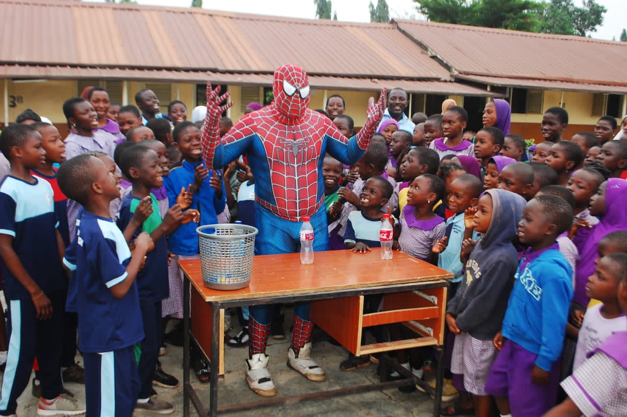 Nigerian Spiderman poses with a class of students.