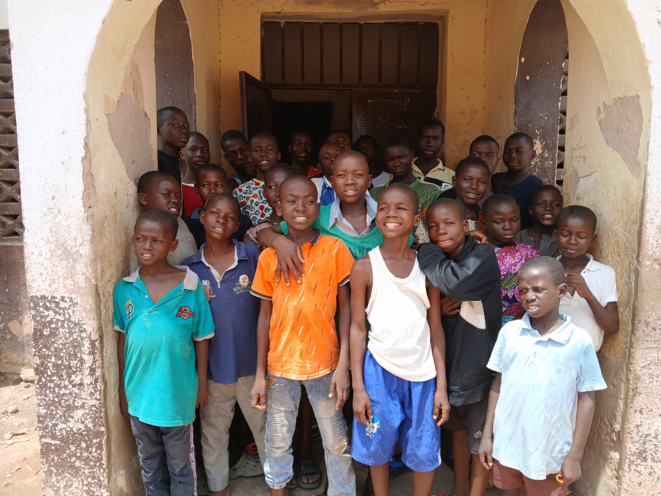 The boys carry smiles enthusiasms as they pose for a picture in front of their hostel. Photo credit: Yahuza Bawage.