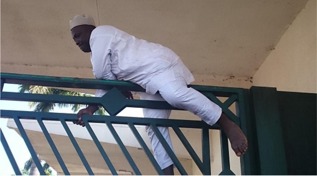 Real image of Usman Cheche on November 20, 2014, crossing over the National Assembly gate.