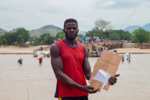 Chukul Yahaya is showing a list of people whose luggage is to be crossed. Photo Ahmed Abubakar Bature.