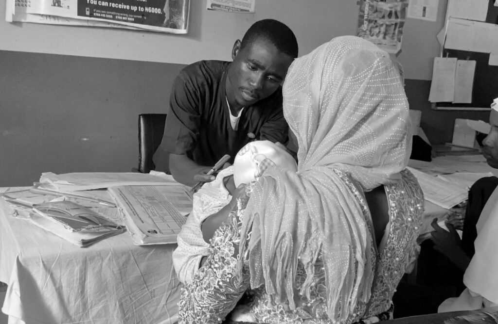 Khalid Boi, routine imunization officer at the Pantami Healthcare centre checking a child. Photo Credit/ Ogar Monday