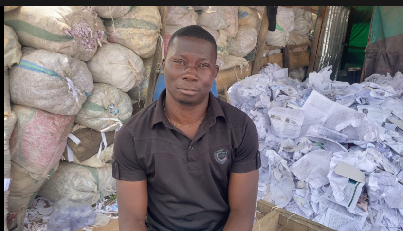 Mr. Ede Joseph Emeka, sitting in front of load of papers.