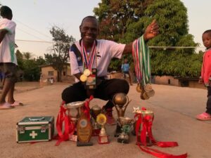 Coach Mumkwaba displaying his medals and trophies