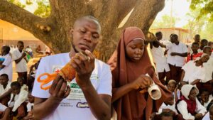 Mohammed and a student tinker with a design at one of his bootcamps. Photograph. Sayedi Umar Mohammed