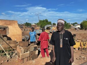 2 Suleiman Isah, a retired government auditor, watches as teenagers help gather the bricks from what used to be his house. Photo taken in Mokwa, Niger State, Nigeria, on 5th June, 2025. Photo credit: Ogar Monday
