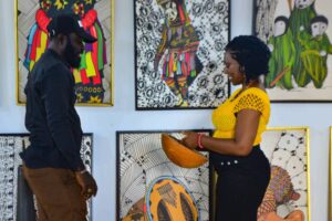 Chief Heritage Officer, Dr Ijeoma Onyejekwe, (left) with the Director of the Centre For Memories, Mr Iheanyi Igboko,(right) playing the “Ubo Aka” an Igbo musical instrument at the Igbo spirituality exhibition in Enugu, Nigeria on October, 22, 2025. Photo: Sam-Eze Chidera Ifeakanwa, bird story agency