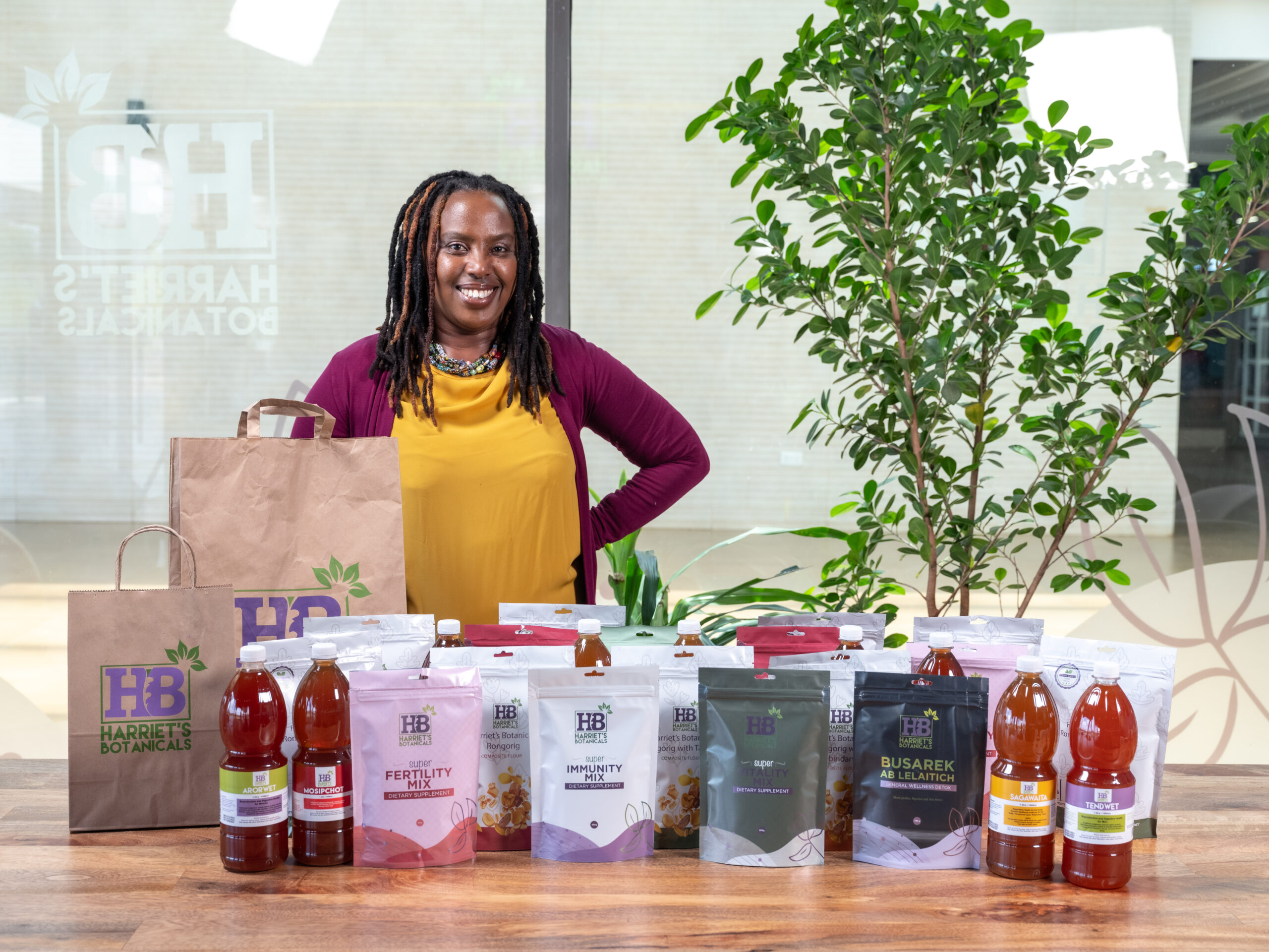 Harriet Chebet posing behind a range of products from Harriet Botanicals in Nairobi, Kenya. Photo credit: Harriet Chebet