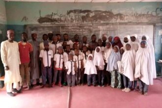 Ibrahim Tukur, other teachers, and the pupils gathered inside a larger classroom. Photo credit: Ibrahim Tukur.