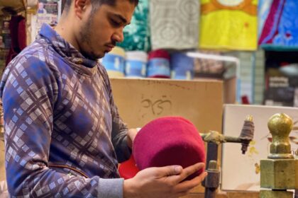 Muhammad El-Baset trimming a customer's Fezze in his shop in Cairo, Egypt. Photo source: Bird story agency