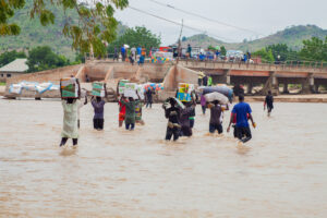 Young people struggling to cross luggage at the Shuwa River following the collapse of the bridge. Photo Ahmed Abubakar Bature.