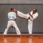 Master Charles(right) demonstrating the Jodan Mawashi geri with student Blessed Paidamoyo (left) in his dojo at the Courtauld Theatre in Mutare, Zimbabwe. Photo: Jacqueline Muchazoreka. Bird story agency