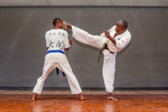 Master Charles(right) demonstrating the Jodan Mawashi geri with student Blessed Paidamoyo (left) in his dojo at the Courtauld Theatre in Mutare, Zimbabwe. Photo: Jacqueline Muchazoreka. Bird story agency