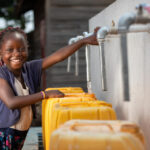 A girl fetching water from a tap. Photo Credit: UN Photo/Gwenn Dubourthoumieu (The Photo is use for illustration purpose)