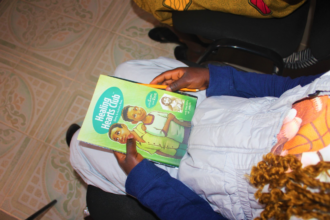 Survivor holding her manual during a trauma counselling group session. Photo credit: CWEENS