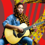 A woman in demin straddles a guitar while staring intently at the camera. Her head is turbanned in Ankara, and her background is coloured by a flowing Ankara material.