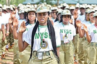A squad of female corps members with their right hands raised in salute. Photo credit: NYSC