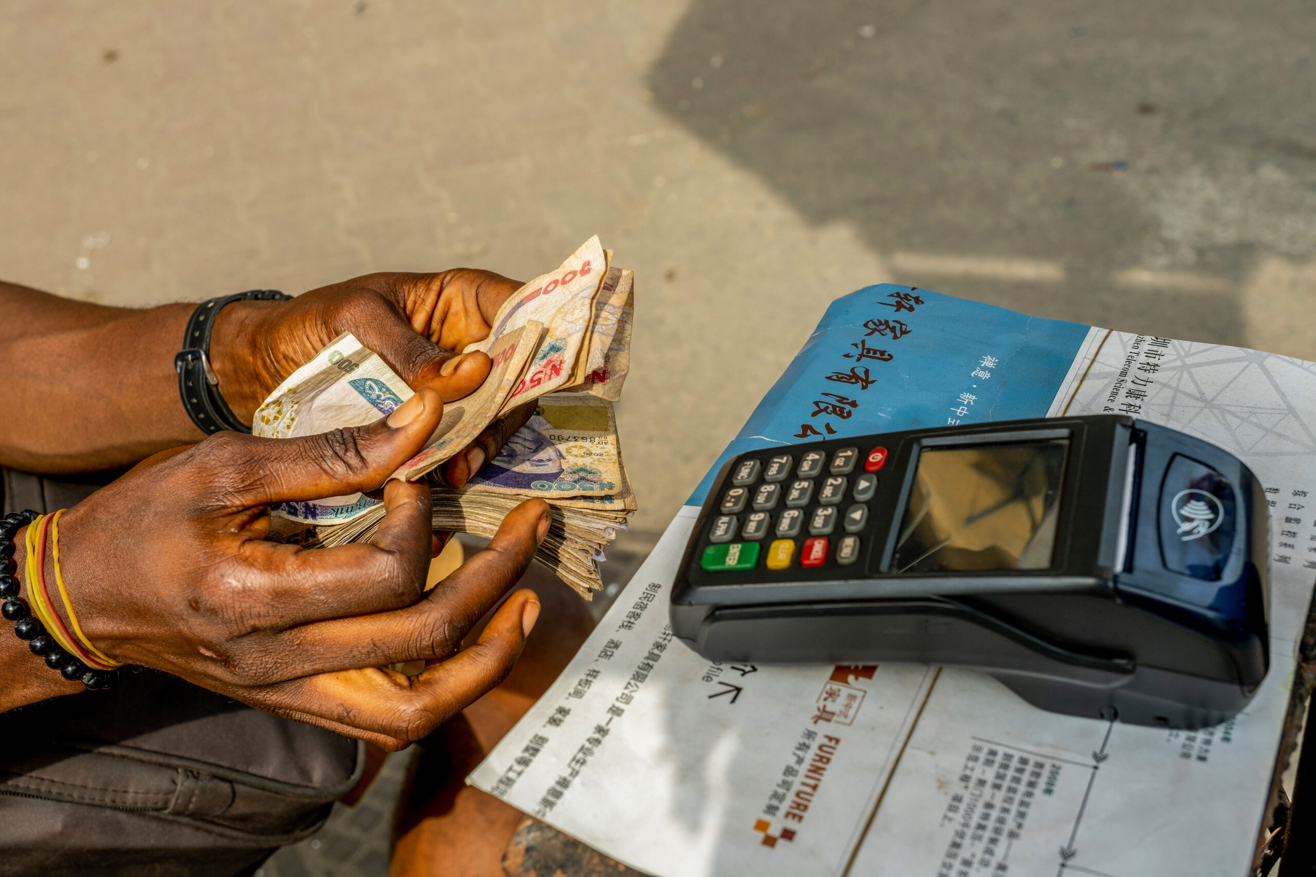 Mobile Point of Sale (POS) operator counts money on Nnamdi Azikwe Street, Lagos Island, Nigeria on 6th January, 2022