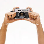 Two hand holding a vintage camera isolated on white background