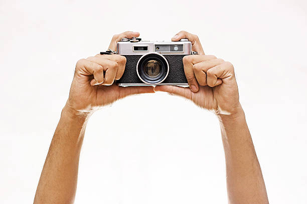 Two hand holding a vintage camera isolated on white background