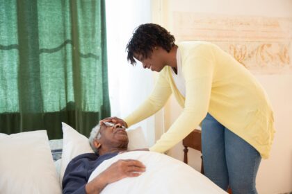 elderly man and smiling caregiver scaled