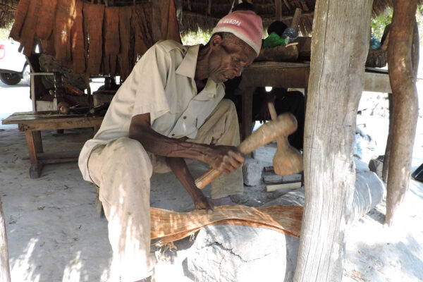 This is a photo of John Mukopa pounding bark in his workshop, used to illustrate the material knowledge program. Credit: EMKP